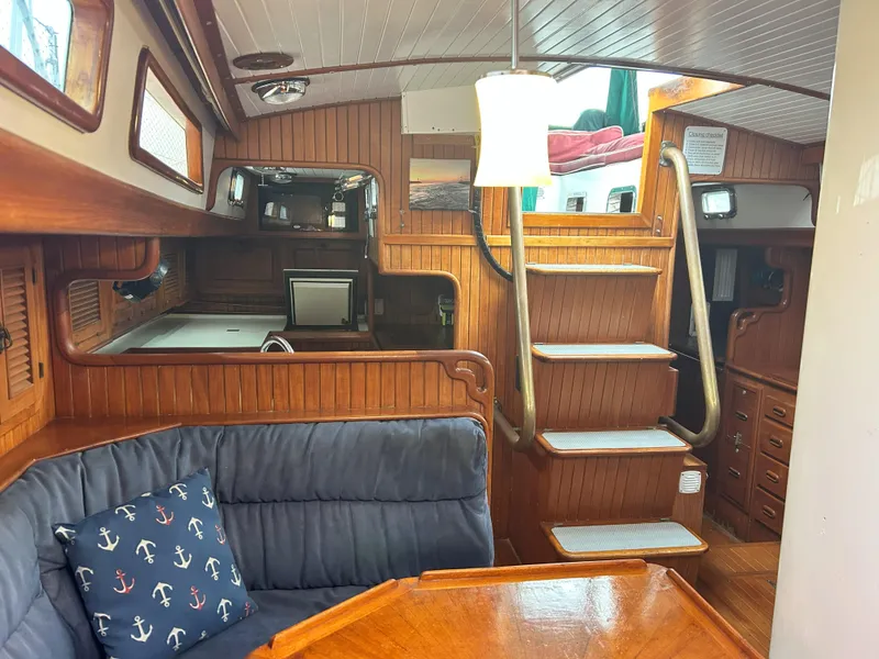 Slide: The Image of Cozy 1987 Passport 51 yacht interior with wooden paneling, stairs, and nautical-themed decor. - 33