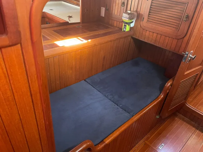 Slide: The Image of Cozy wooden cabin interior with a single bed on a 1987 Passport 51 sailboat. - 36