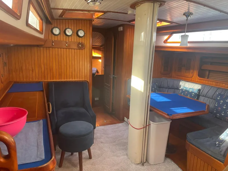 Slide: The Image of Interior of a 1987 Passport 51 yacht with wooden paneling and cozy seating area. - 40