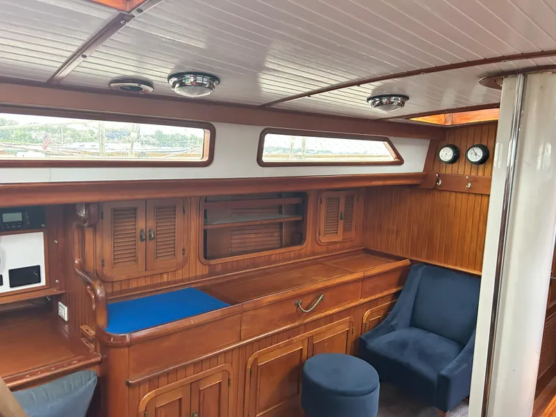 Slide: The Image of Interior of a 1987 Passport 51 yacht with wooden cabinetry and blue seating. - 41