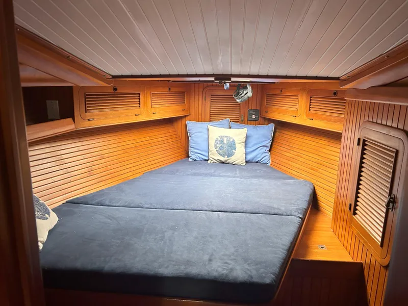 Slide: The Image of Cozy cabin interior of 1987 Passport 51 yacht with wooden paneling and blue bedding. - 43