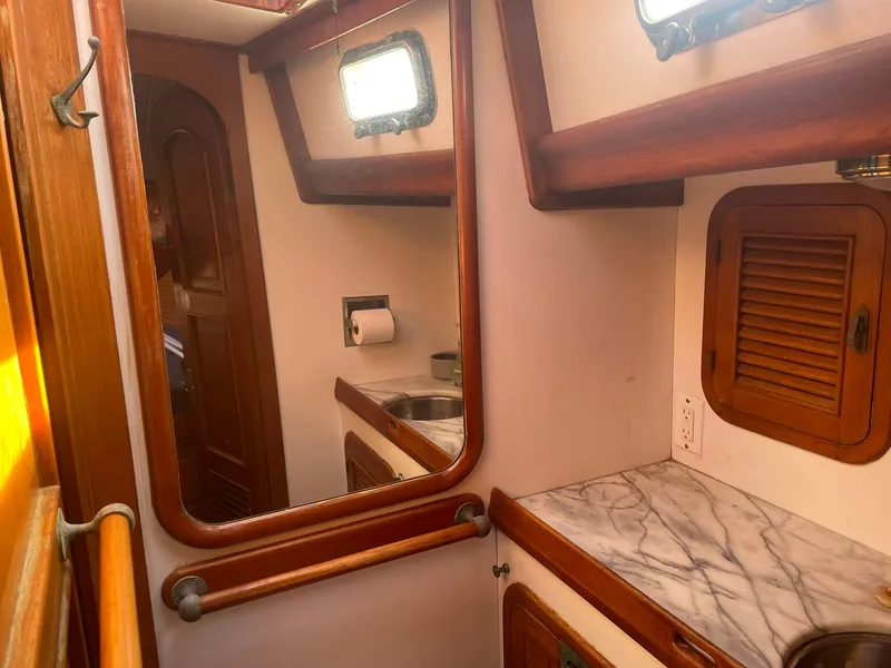 Slide: The Image of 1987 Passport 51 yacht bathroom with wooden accents and marble countertop. - 46
