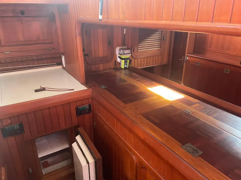Slide: The Image of Wooden interior of a 1987 Passport 51 yacht, featuring cabinets and a countertop. - 50