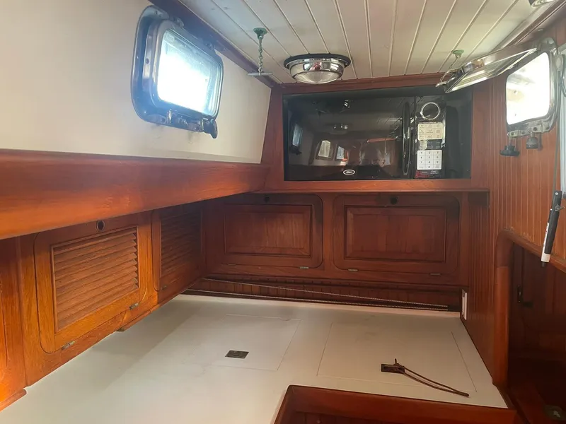 Slide: The Image of Interior of a 1987 Passport 51 sailboat with wooden cabinetry and microwave. - 51