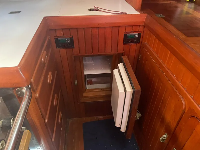 Slide: The Image of Wooden interior of 1987 Passport 51 yacht with open storage compartment. - 52