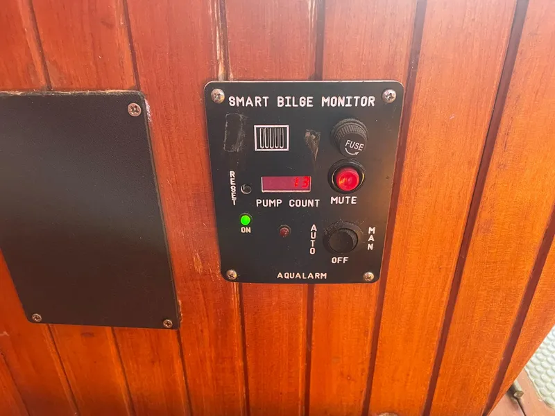 Slide: The Image of Smart bilge monitor panel on wooden surface, featuring controls and indicators, model Passport 51, 1987. - 53