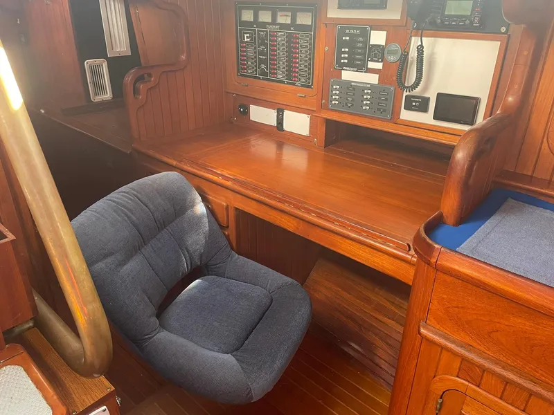 Slide: The Image of Interior of a 1987 Passport 51 sailboat with wooden desk and blue chair. - 56