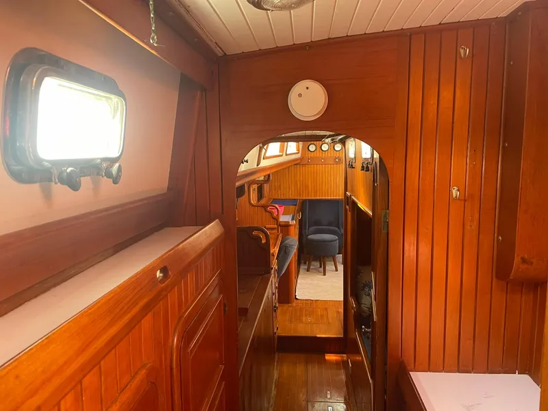 Slide: The Image of Interior of 1987 Passport 51 sailboat with wooden paneling and porthole window. - 58