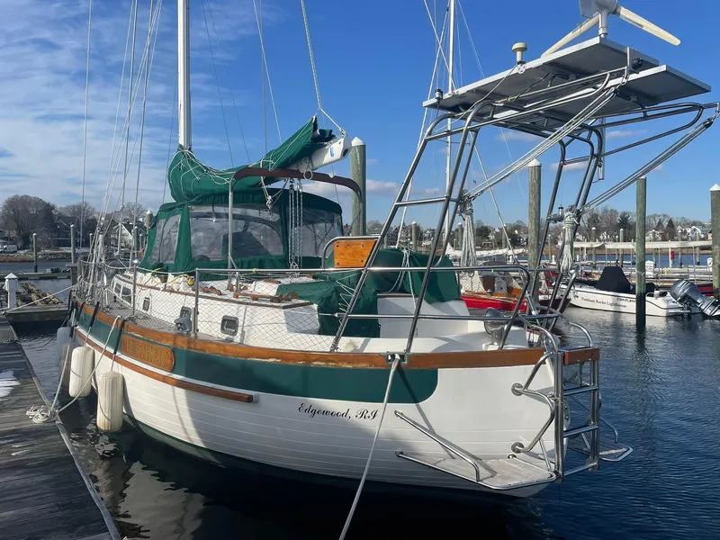 Slide: The Image of 1987 Passport 51 sailboat docked at marina, featuring green canopy and wooden accents. - 6