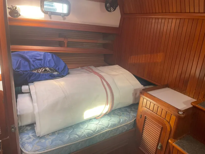 Slide: The Image of Cozy cabin interior of 1987 Passport 51 sailboat with wooden paneling and storage. - 61