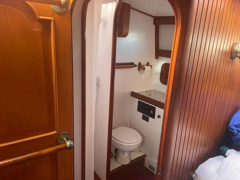 Slide: The Image of Wood-paneled bathroom in 1987 Passport 51 yacht with toilet and storage. - 69