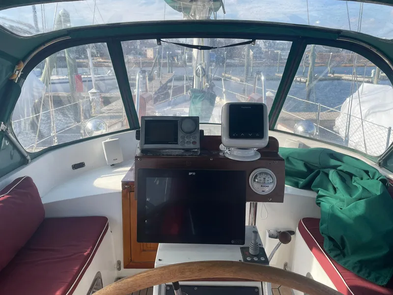 Slide: The Image of Cockpit of 1987 Passport 51 sailboat with navigation equipment and marina view. - 9