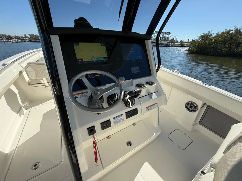 Slide: The Image of 2025 World Cat 280 CC-X boat cockpit with steering wheel and navigation display. - 12