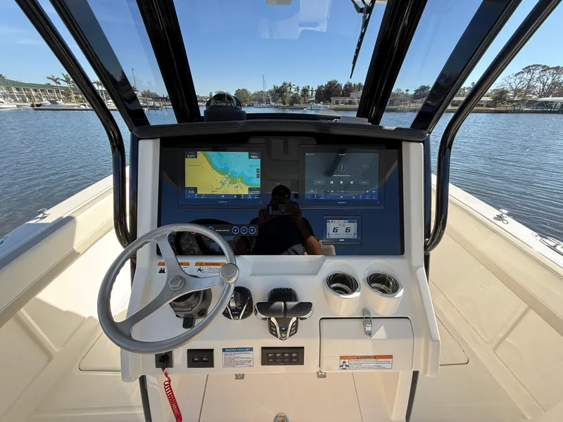 Slide: The Image of 2025 World Cat 280 CC-X boat dashboard with navigation screens and steering wheel. - 13