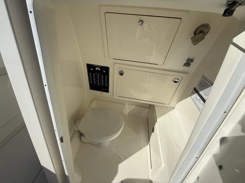 Slide: The Image of 2025 World Cat 280 CC-X boat interior with compact marine toilet and storage compartments. - 14