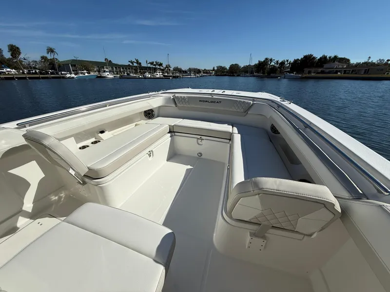 Slide: The Image of 2025 World Cat 280 CC-X boat interior with spacious seating, docked on a sunny day. - 15