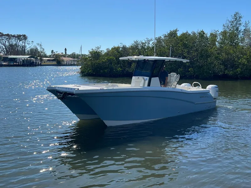 Slide: The Image of 2025 World Cat 280 CC-X boat on calm water, surrounded by trees. - 3