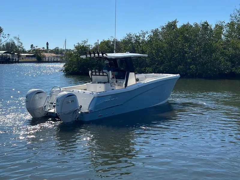 Slide: The Image of 2025 World Cat 280 CC-X boat on calm water, surrounded by greenery. - 5