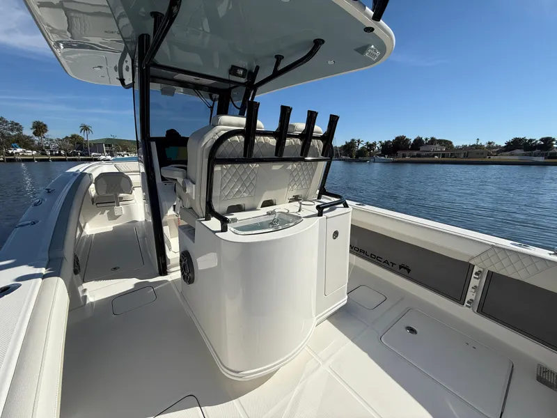 Slide: The Image of 2025 World Cat 280 CC-X boat interior with fishing rod holders, sleek design, and waterfront view. - 8