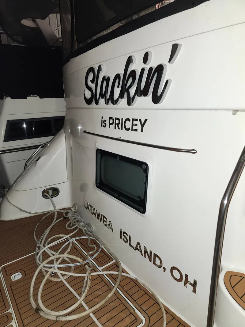 Slide: The Image of 1996 Sea Ray 420 Aft Cabin boat with "Slackin' is PRICEY" text, docked at Catawba Island, OH. - 13