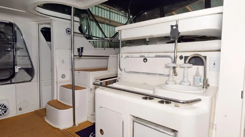 Slide: The Image of 1996 Sea Ray 420 Aft Cabin interior with stairs and kitchenette area. - 17