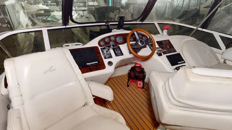 Slide: The Image of 1996 Sea Ray 420 Aft Cabin helm with leather seats and wooden steering wheel. - 18