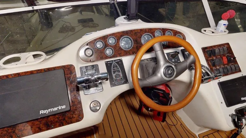 Slide: The Image of 1996 Sea Ray 420 Aft Cabin helm with Raymarine electronics and wood-accented steering wheel. - 19