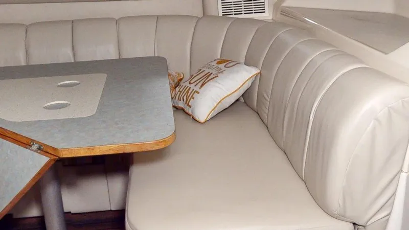 Slide: The Image of 1996 Sea Ray 420 Aft Cabin interior with cushioned seating and table. - 4