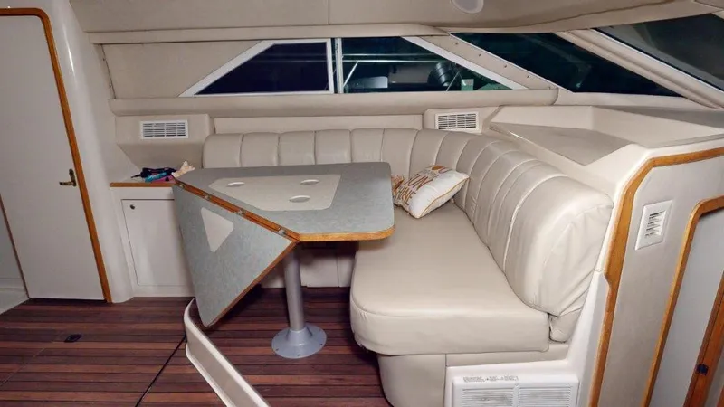 Slide: The Image of 1996 Sea Ray 420 Aft Cabin interior with beige seating and wooden accents. - 5