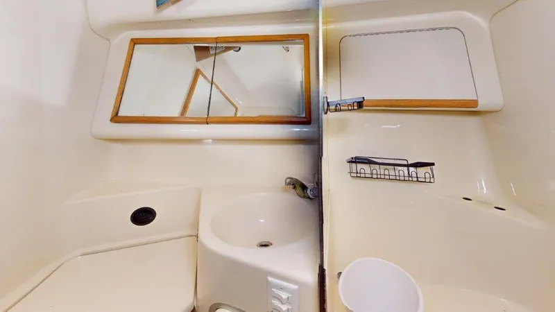 Slide: The Image of 1996 Sea Ray 420 Aft Cabin bathroom with sink, mirror, and storage shelf. - 6