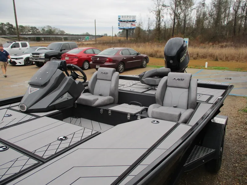 Slide: The Image of 2025 Avid 18 Vertex boat with sleek design, parked near cars. - 8