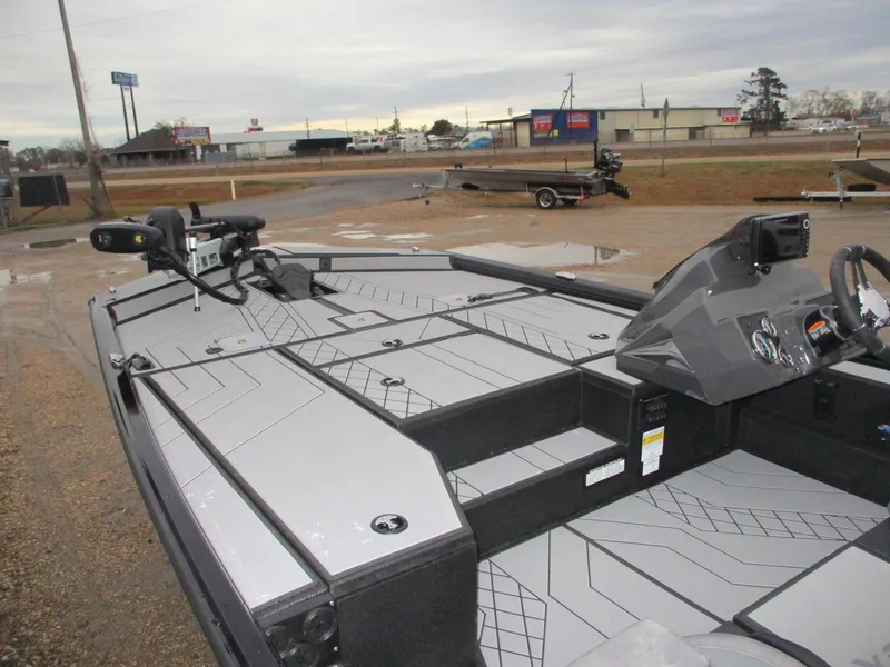 Slide: The Image of 2025 Avid 18 Vertex boat with sleek deck design in a parking area. - 9