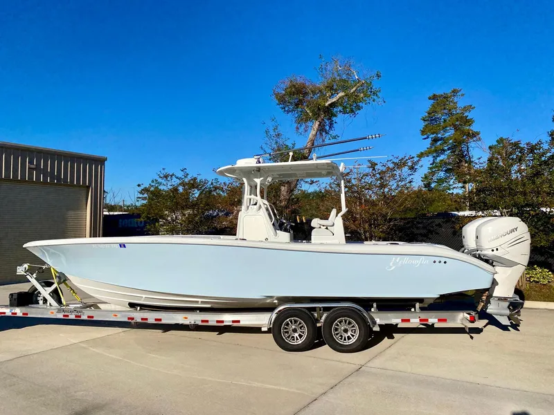 Slide: The Image of 2019 Yellowfin 29 Offshore boat on trailer, parked outdoors under clear blue sky. - 0