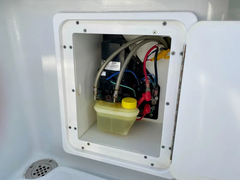Slide: The Image of 2019 Yellowfin 29 Offshore boat compartment with wiring and fluid container. - 11