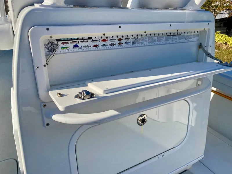 Slide: The Image of 2019 Yellowfin 29 Offshore boat with fish identification chart and storage compartment. - 12