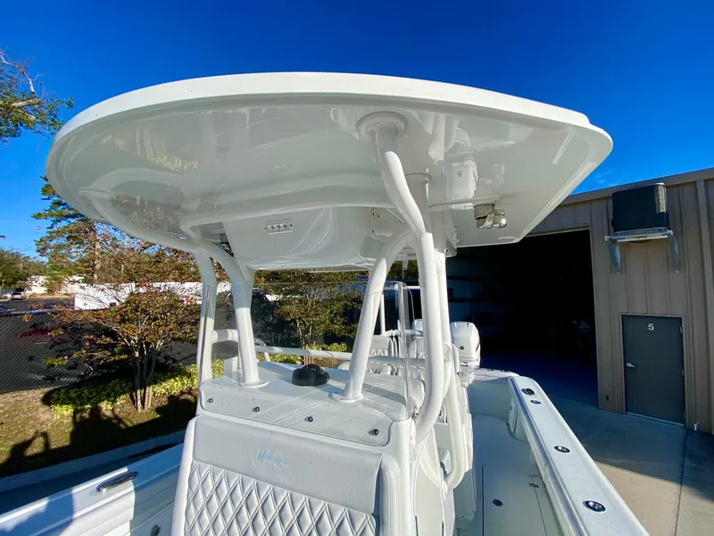 Slide: The Image of 2019 Yellowfin 29 Offshore boat with T-top, parked outdoors under clear blue sky. - 17