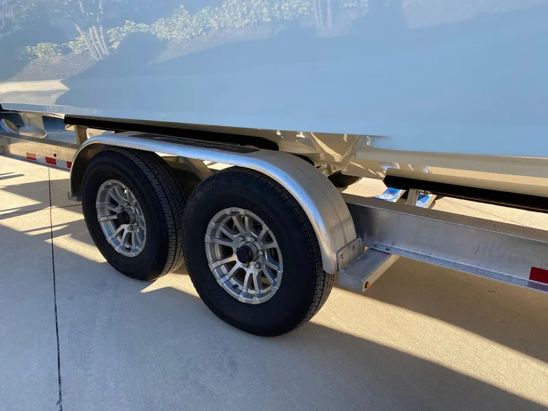 Slide: The Image of Trailer wheels of a 2019 Yellowfin 29 Offshore boat on pavement. - 7
