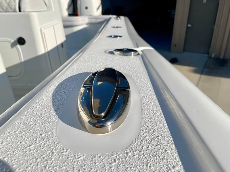 Slide: The Image of Close-up of a 2019 Yellowfin 29 Offshore boat's sleek stainless steel cleat on textured surface. - 9
