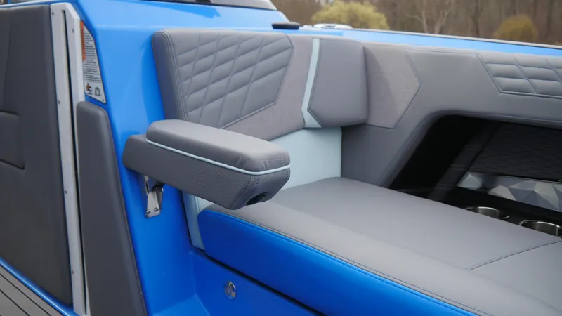 Slide: The Image of 2023 Nautique Super Air G23 interior with blue and gray seating, featuring quilted design. - 13
