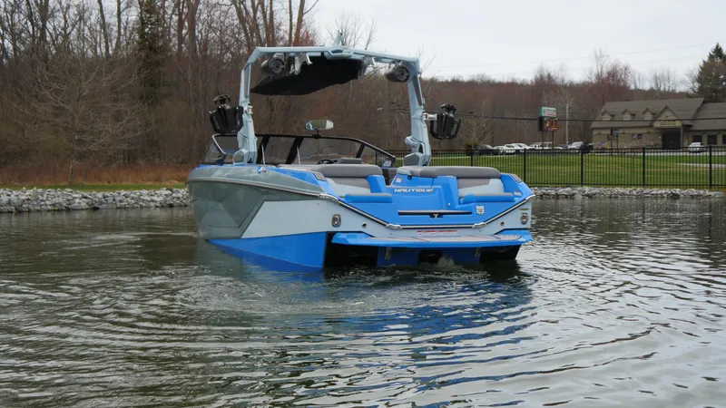 Slide: The Image of 2023 Nautique Super Air G23 boat on a calm lake, showcasing sleek design. - 3