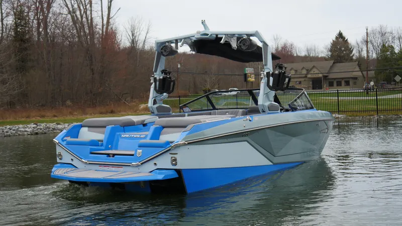 Slide: The Image of 2023 Nautique Super Air G23 boat on water, showcasing sleek design and vibrant blue accents. - 4