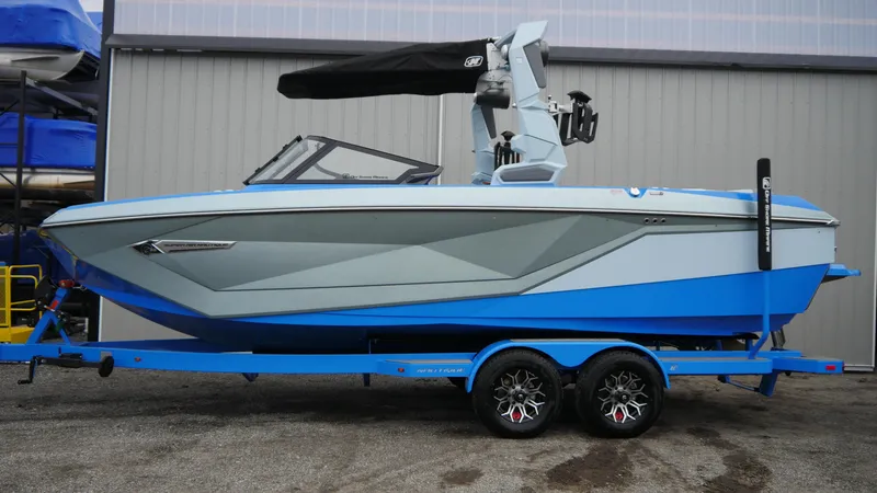 Slide: The Image of 2023 Nautique Super Air G23 boat on trailer, blue and gray design. - 5