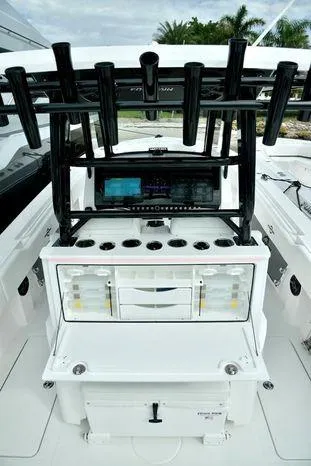 Slide: The Image of 2024 Fountain Bluewater 38 Tournament Edition boat console with rod holders and storage compartments. - 10