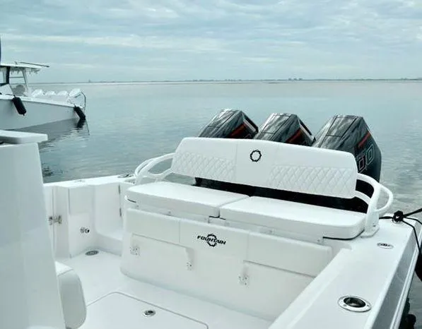 Slide: The Image of 2024 Fountain Bluewater 38 Tournament Edition boat with triple engines on calm water. - 11