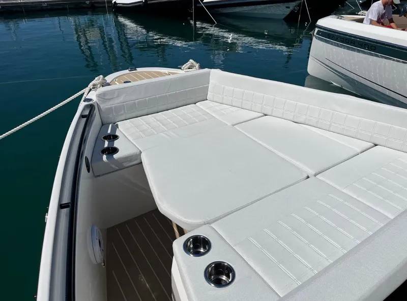 Slide: The Image of 2025 Saxdor 340 GTWA boat interior with seating and table, docked at marina. - 17