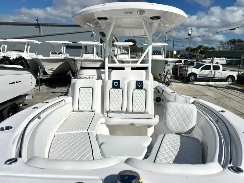 Slide: The Image of 2025 Sea Fox 248 Side Console boat with white seating and canopy, docked outdoors. - 14