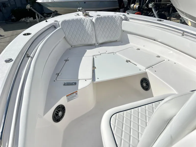 Slide: The Image of 2025 Sea Fox 248 Side Console boat interior with white cushioned seating and storage compartments. - 20