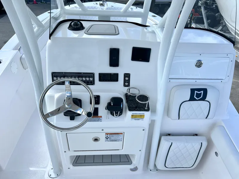 Slide: The Image of 2025 Sea Fox 248 Side Console boat dashboard with steering wheel and controls. - 36