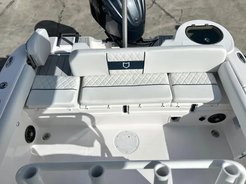 Slide: The Image of 2025 Sea Fox 248 Side Console boat interior with white cushioned seating and motor. - 42