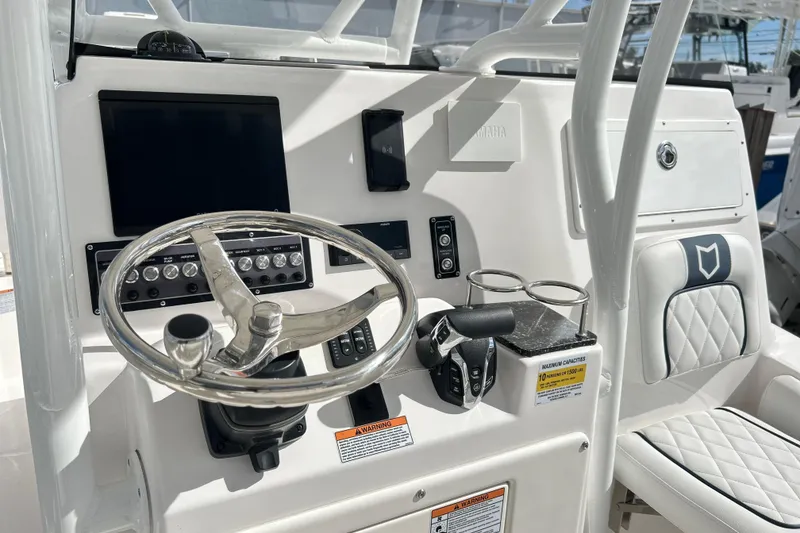 Slide: The Image of 2025 Sea Fox 248 Side Console boat dashboard with steering wheel and controls. - 63